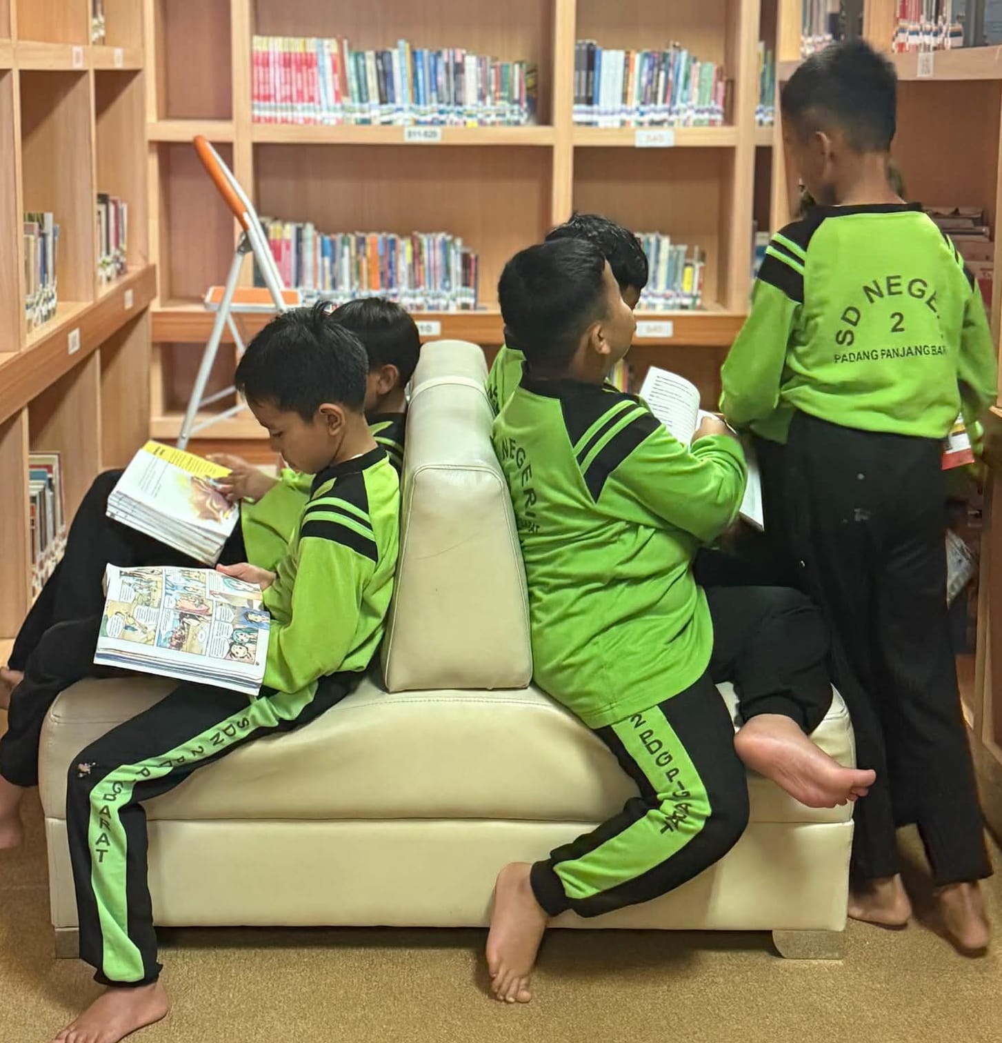 Beberapa siswa asyik memilih dan membaca di kantor dinas perpustakaan.